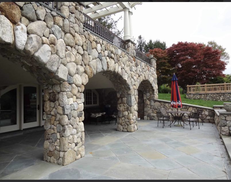 Stone patio with arches and umbrella