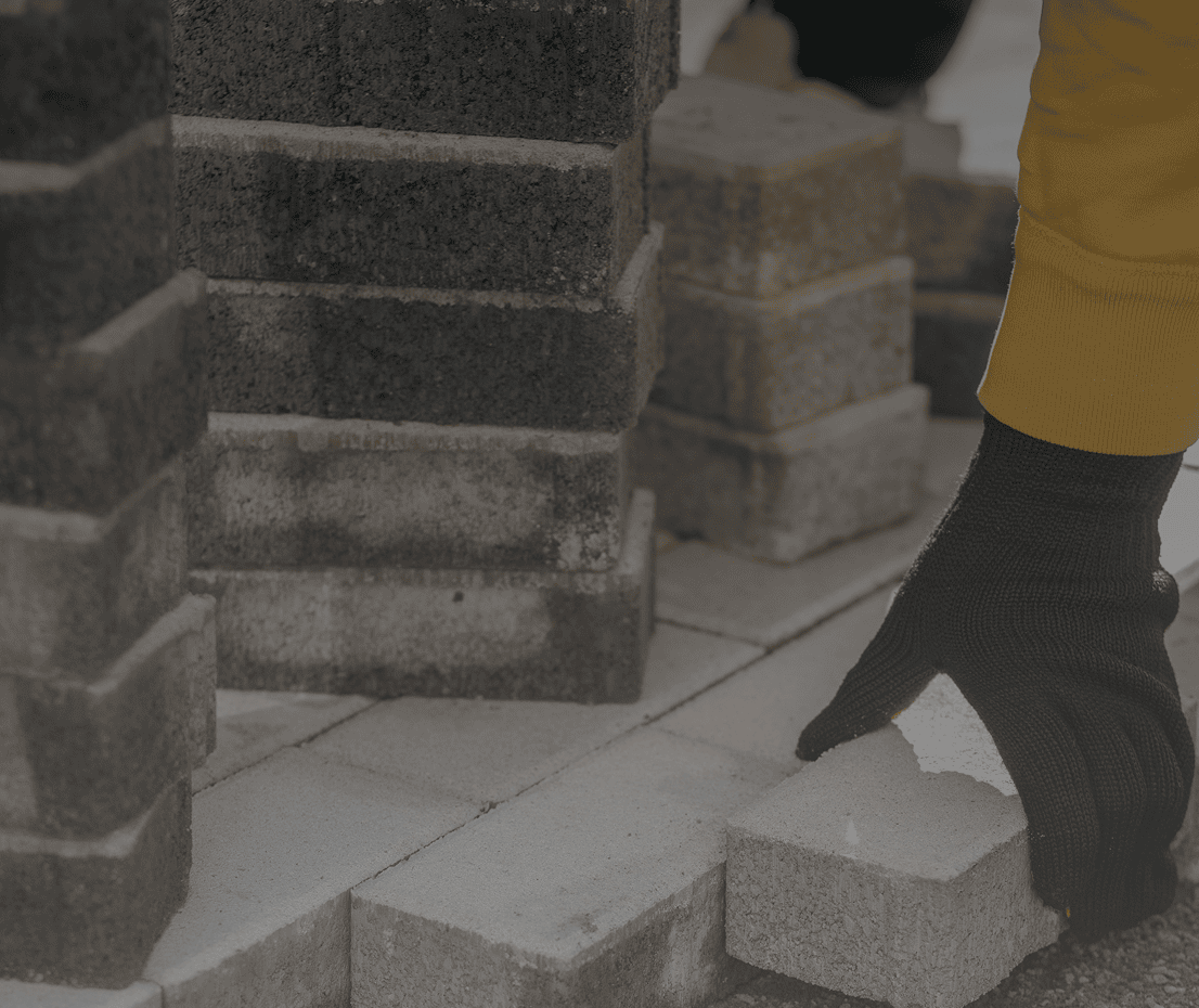 Gloved hand arranging bricks