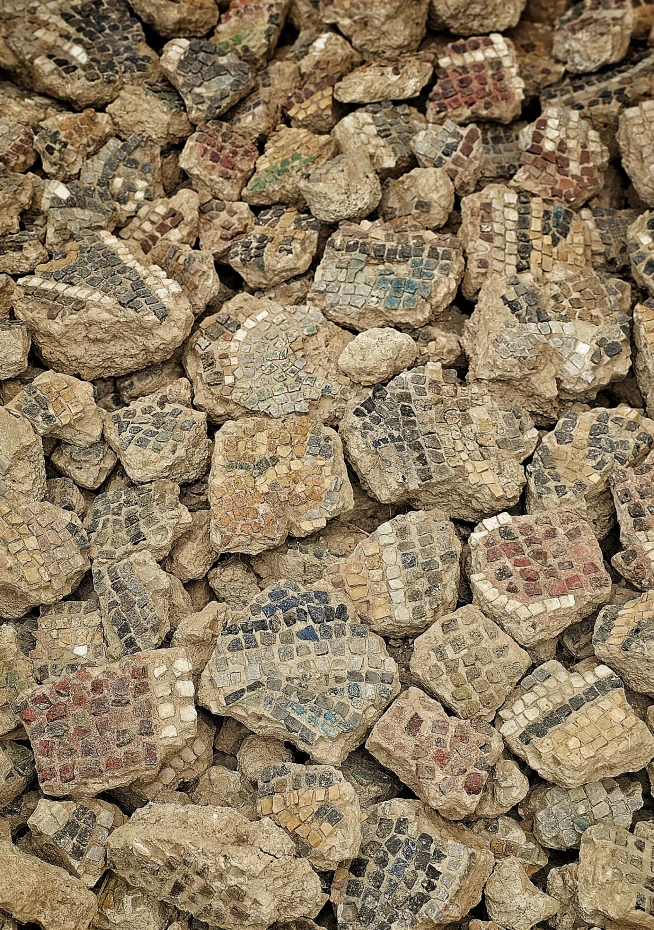 Colorful mosaic fragments scattered on dirt